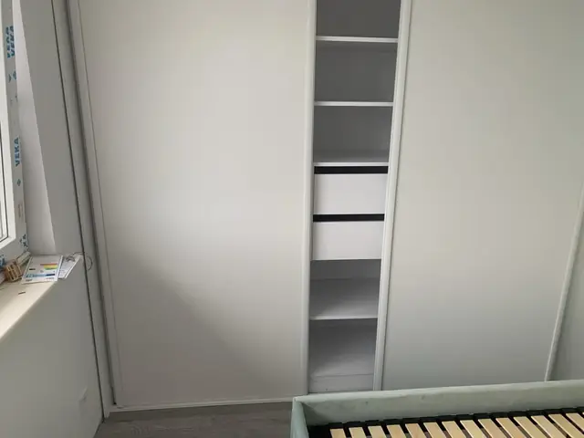 Wnętrze białej szafy przesuwnej z szufladami